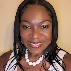 Profile photo of Maxine Samuels, in a white top with pearls.