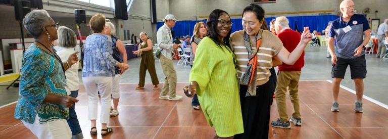 Friends and colleagues dance at the 2025 Summer BBQ
