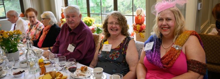 Smiling attendees enjoy the tea at Endicott House