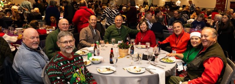 Gathered attendees smile for the camera during the Holiday party.