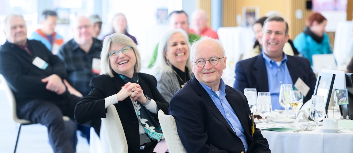 President Kornbluth honors the 2025-2026 class of Quarter Century Club members alongside Bonny Kellermann. A gold club member, Prof. Harry Tuller smiles in the foreground.